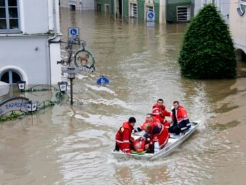 A rescue team on a dinghy evacuates a man from the flooded district of the Bavarian town of Passau