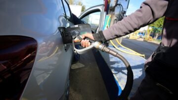 An employee fills the tank of a car with liquefied petroleum gas (LPG) at a petrol station in Algiers
