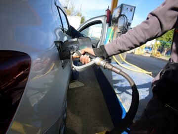 An employee fills the tank of a car with liquefied petroleum gas (LPG) at a petrol station in Algiers