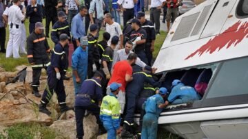 Rescue workers check the debris of an overturned tourist bus in northern Morocco